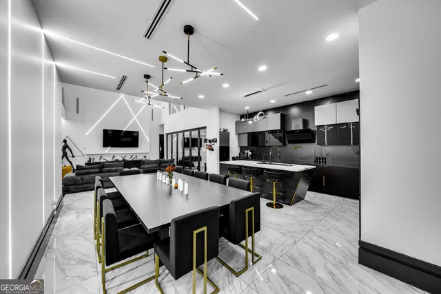 a kitchen with stainless steel appliances kitchen island granite countertop a sink table and chairs in it