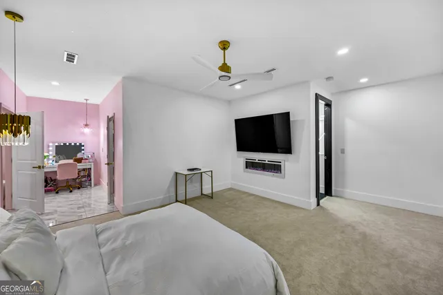 a spacious bedroom with a bed and a chandelier