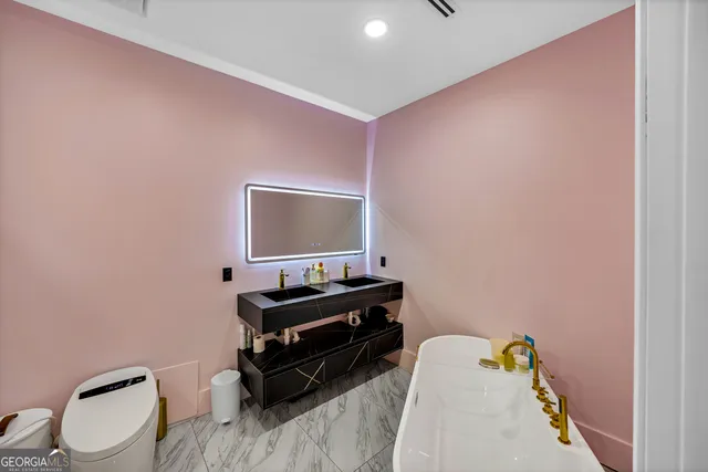 a bathroom with a sink vanity mirror and toilet