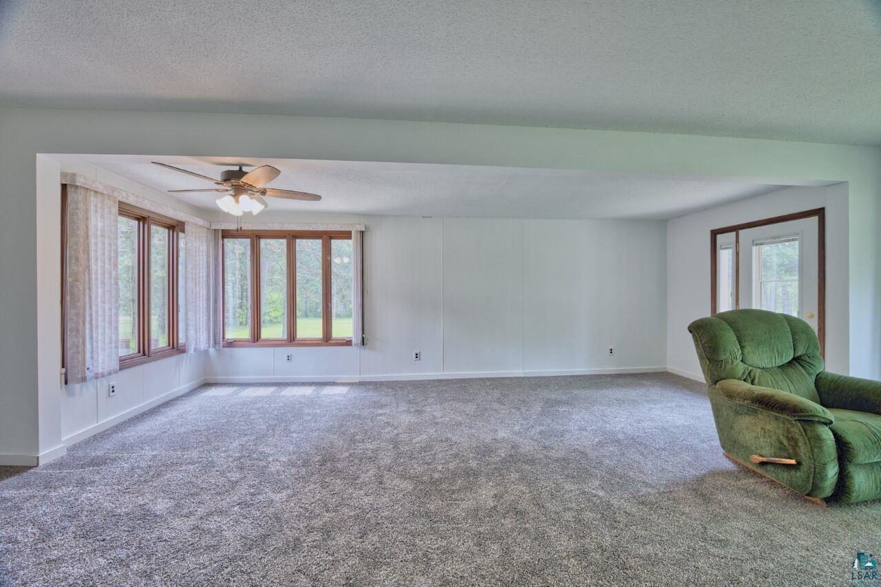 4755 Judd Road Gilbert, MN 55741 - Photo 4 of 50 Unfurnished living room with a ceiling fan, carpet flooring, a textured ceiling, and baseboards