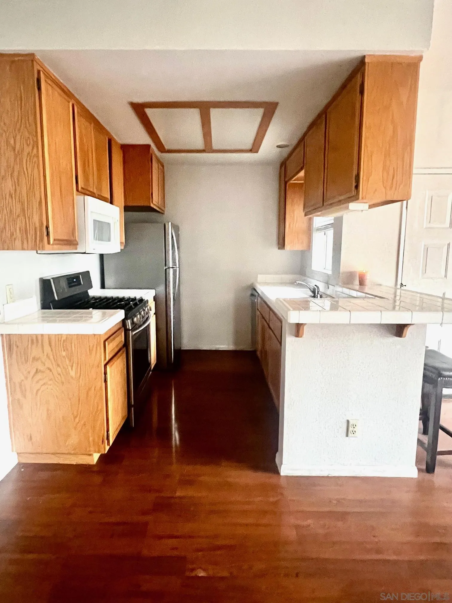 13802 Midland Road Poway, CA 92064 - Photo 2 of 12 a kitchen with a stove top oven sink and wooden floor
