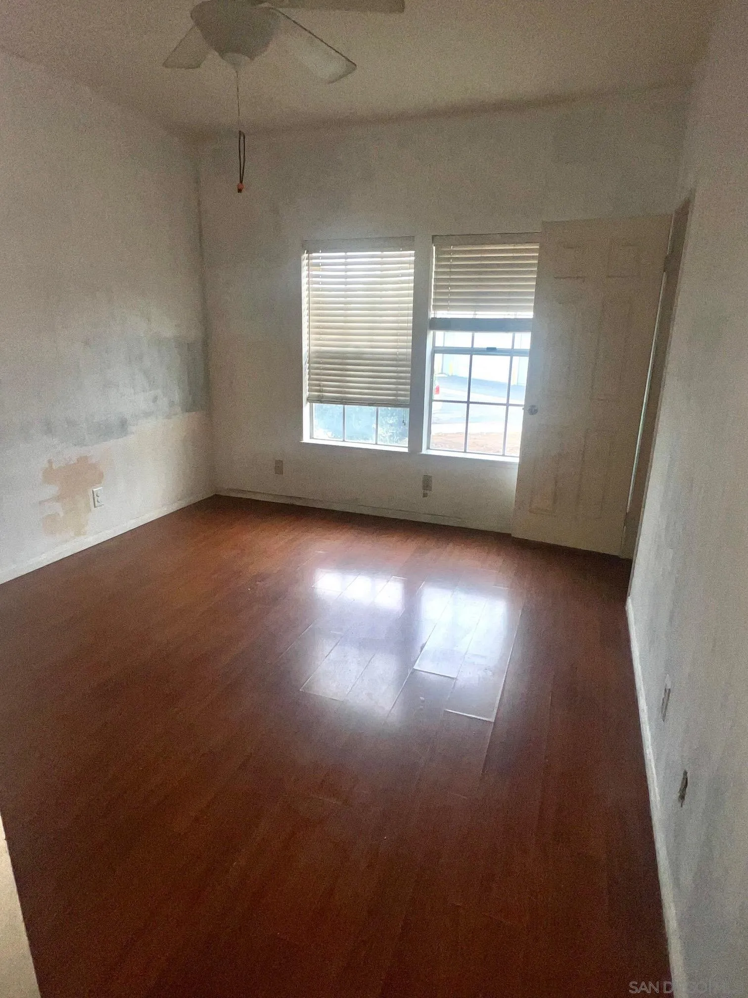 13802 Midland Road Poway, CA 92064 - Photo 6 of 12 an empty room with wooden floor and windows