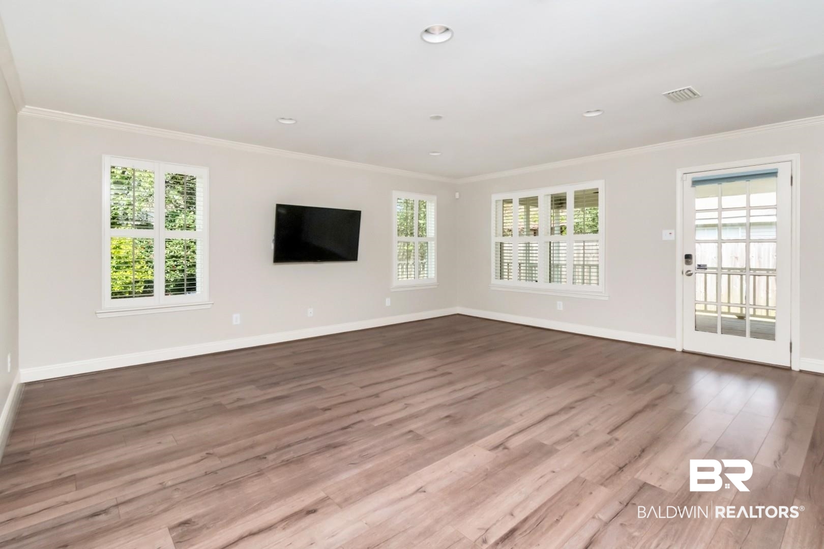 8 Lancaster Road Mobile, AL 36608 - Photo 10 of 24 Unfurnished living room with dark wood finished floors, crown molding, and recessed lighting
