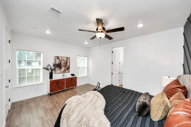 a bedroom with a bed and wooden floor