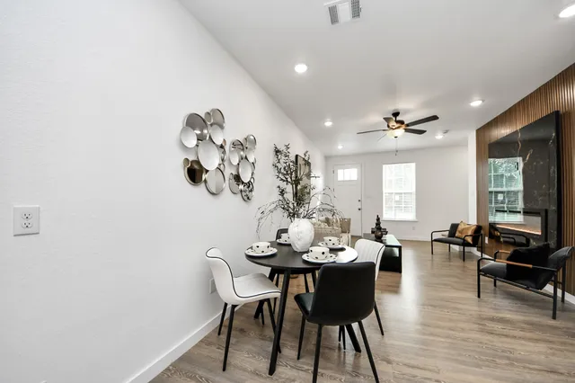 a dining room with furniture potted plants and wooden floor