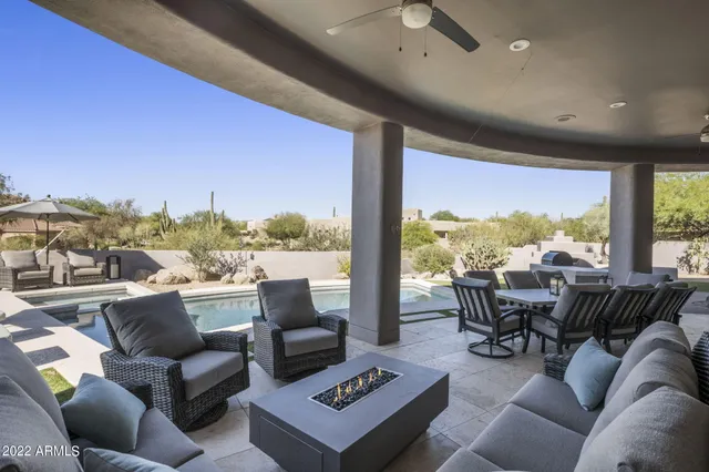 a view of a patio with table and chairs under an umbrella