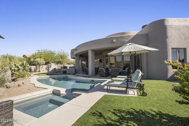 a view of a patio with couches table and chairs with wooden floor and fence