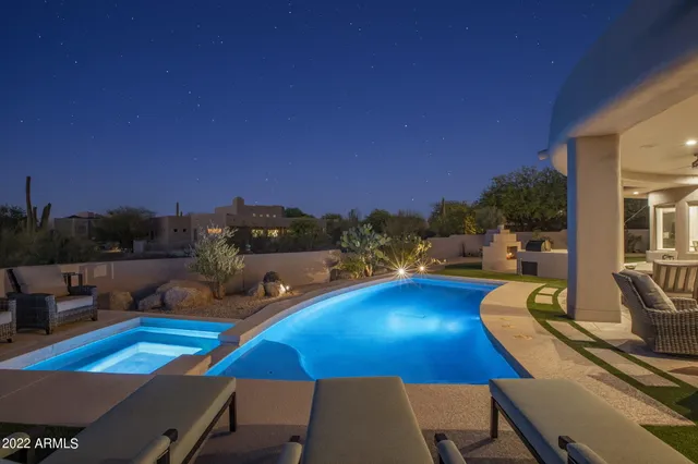 a view of an outdoor dining space with furniture and city view