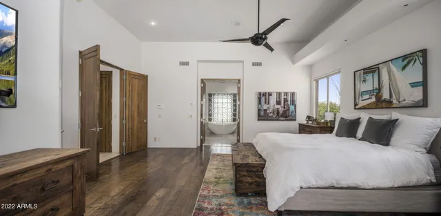 a bedroom with a large bed and a chandelier