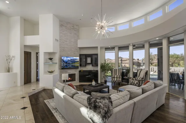 a living room with fireplace furniture and a large window