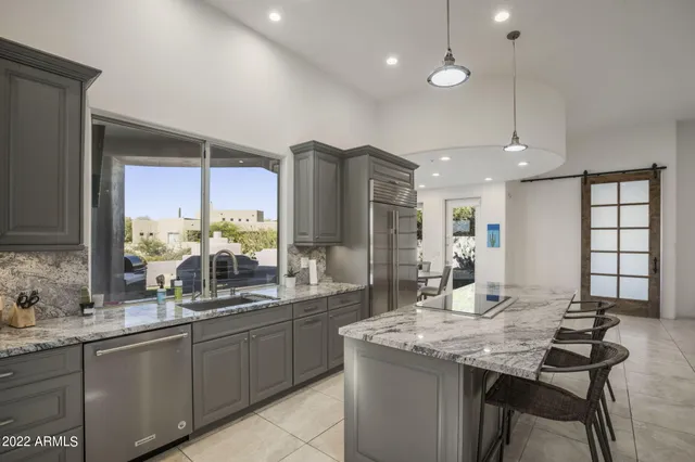 a kitchen with granite countertop a refrigerator and cabinets
