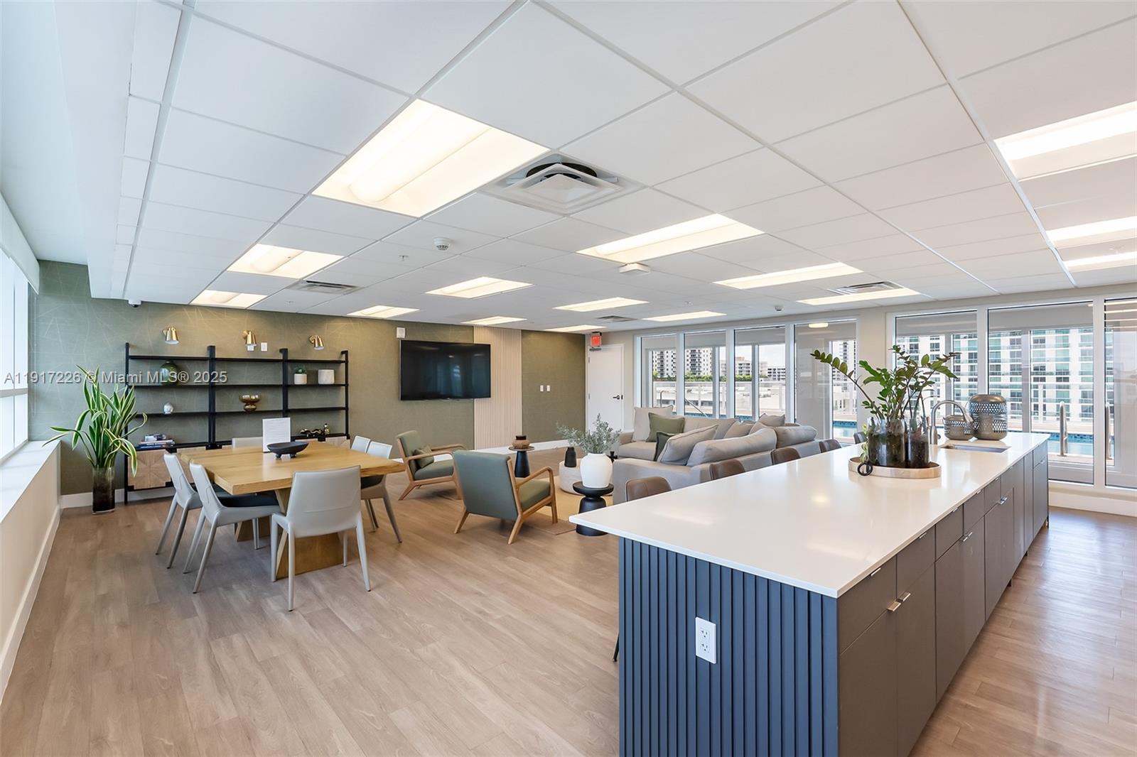 321 Northeast 26th Street, Unit 614 Miami, FL 33137 - Photo 19 of 22 a large living room with stainless steel appliances kitchen island granite countertop a large kitchen island a stove a couch and a dining table with wooden floor