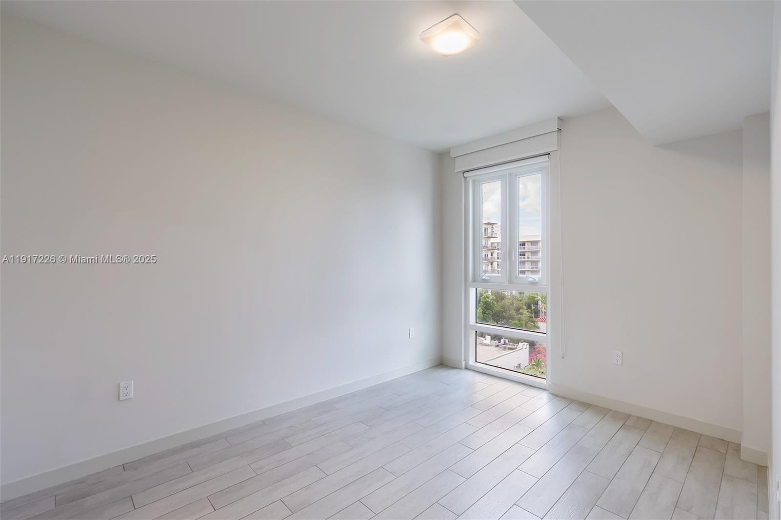 321 Northeast 26th Street, Unit 614 Miami, FL 33137 - Photo 6 of 22 an empty room with wooden floor and windows