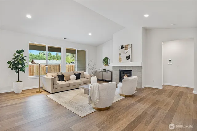 a living room with furniture a fireplace and a potted plant