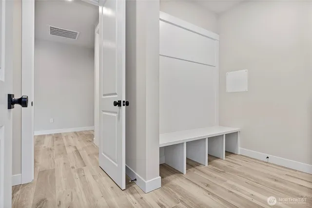 an empty room with wooden floor and a ceiling fan