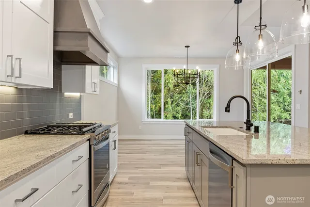 a kitchen with granite countertop a sink stove and cabinets