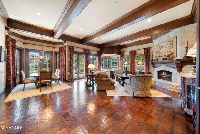 a living room with fireplace furniture and a large window