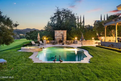 a view of a swimming pool with a bench and trees around