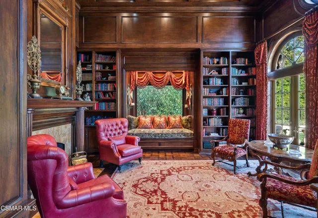 a living room with furniture a bookshelf and a large window