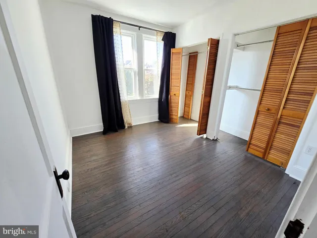 a view of a hallway with wooden floor and stairs