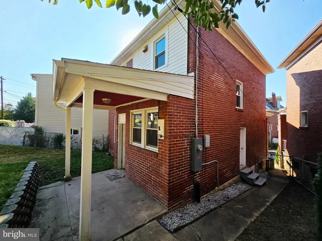 a view of a house with a yard and large tree