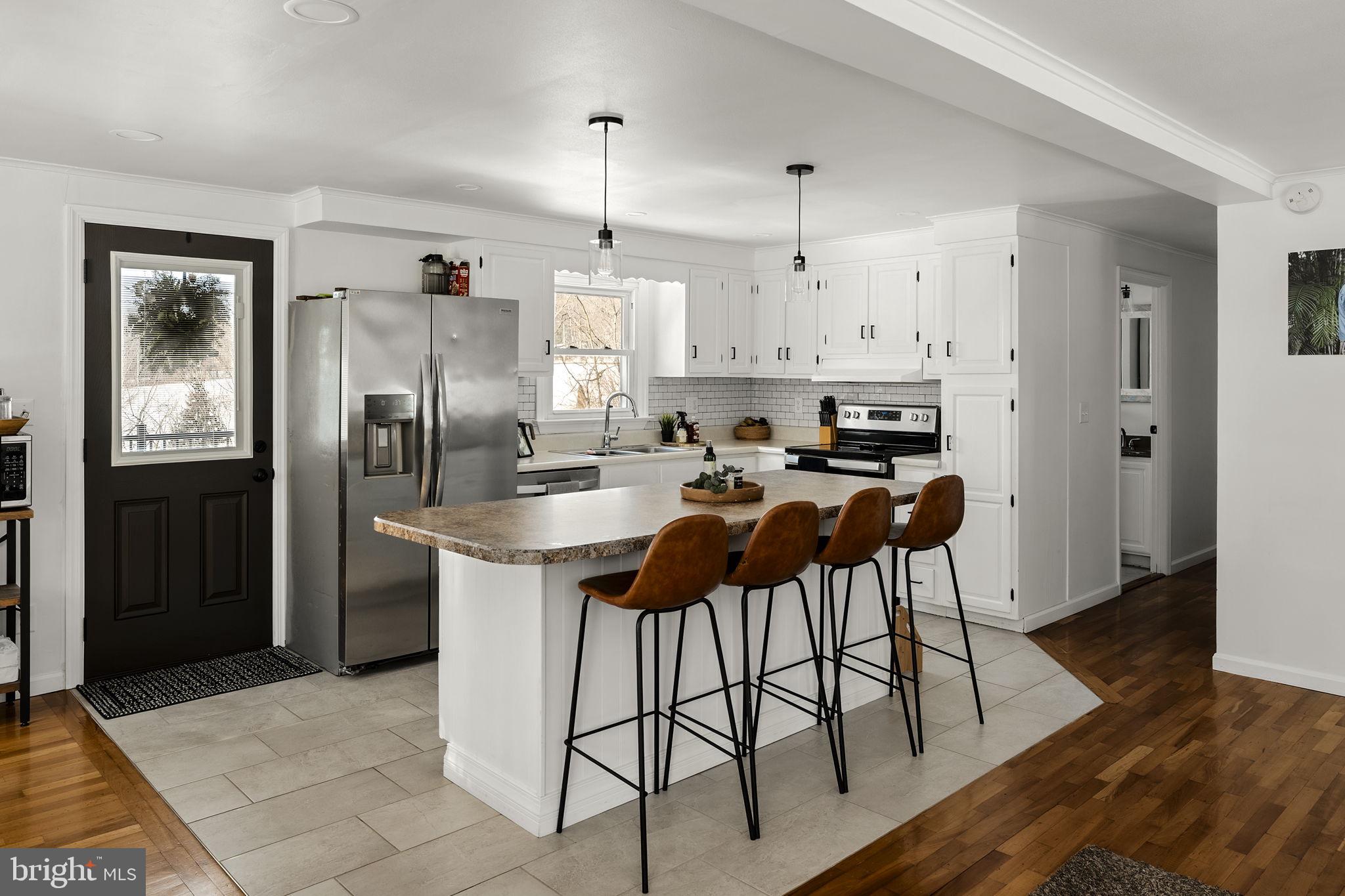 108 Red Well Road New Holland, PA 17557 - Photo 30 of 59 a kitchen with stainless steel appliances granite countertop a refrigerator a sink and white cabinets