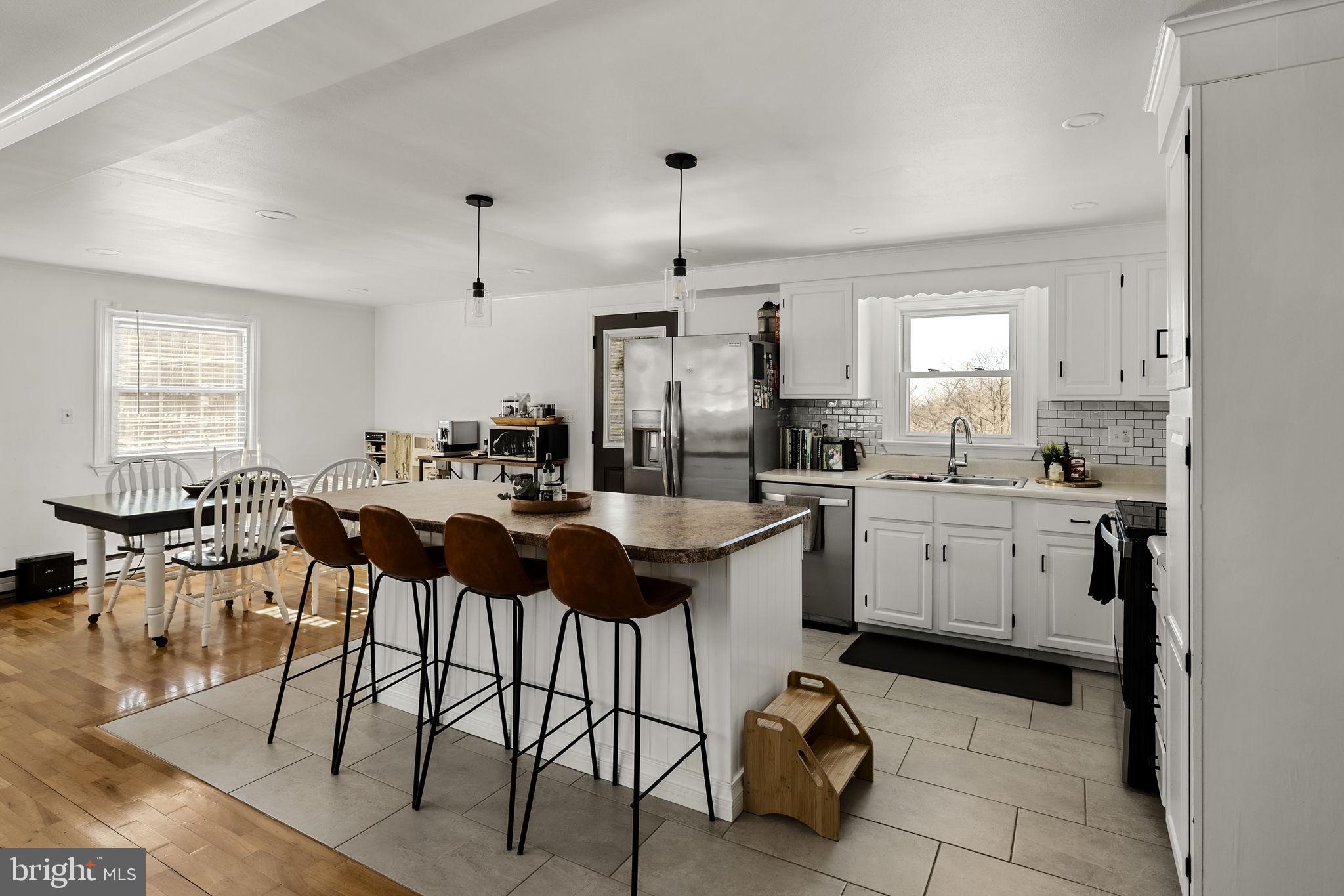 108 Red Well Road New Holland, PA 17557 - Photo 31 of 59 a kitchen with a dining table chairs and white cabinets