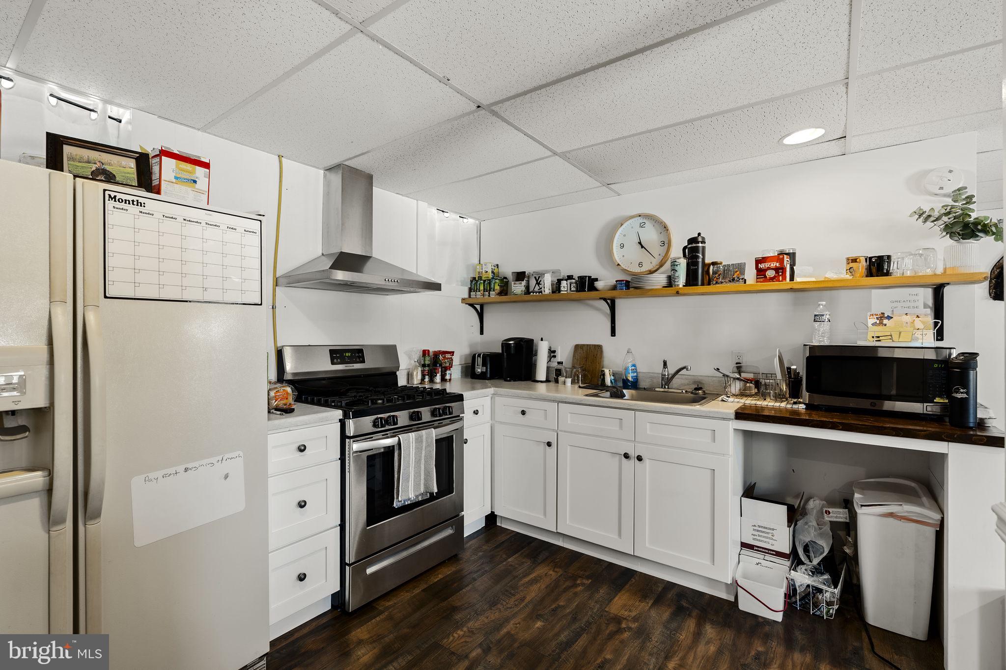108 Red Well Road New Holland, PA 17557 - Photo 52 of 59 a kitchen with a stove a refrigerator and a sink with wooden floor