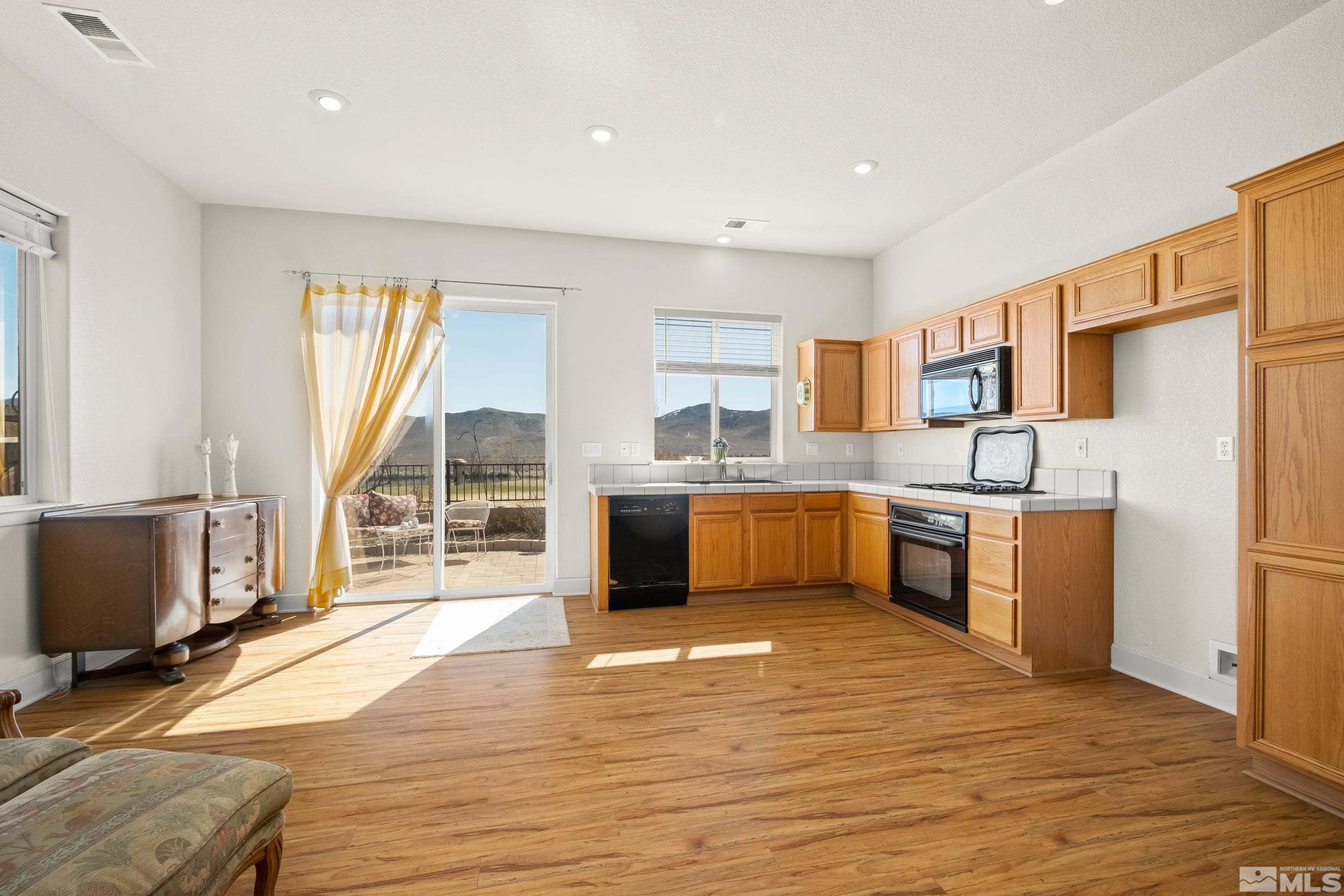 3463 Long Drive Minden, NV 89423 - Photo 10 of 40 a kitchen with stainless steel appliances granite countertop a stove a sink dishwasher a refrigerator and a microwave oven with wooden floor