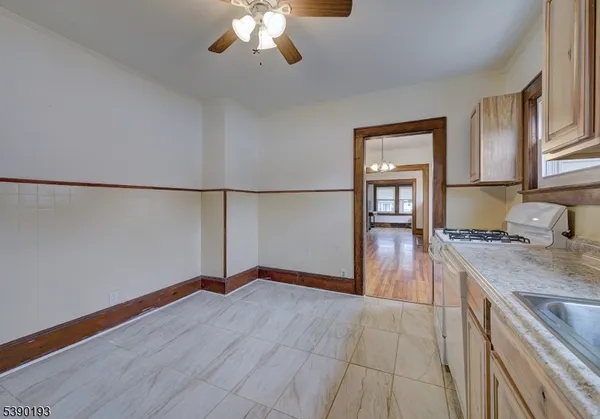 a kitchen with granite countertop a stove a refrigerator and a stove with wooden floor