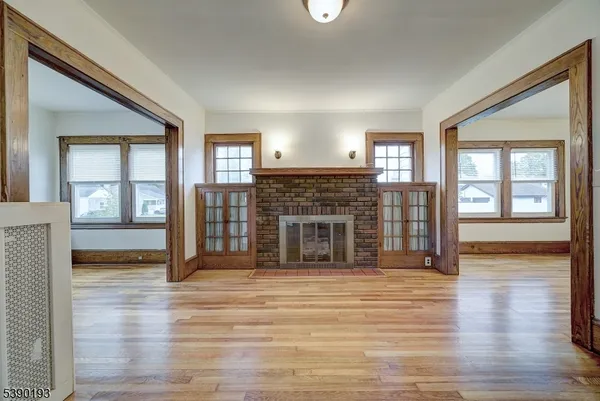 a view of a livingroom with wooden floor and a fireplace