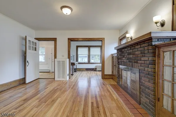 an empty room with wooden floor and fireplace