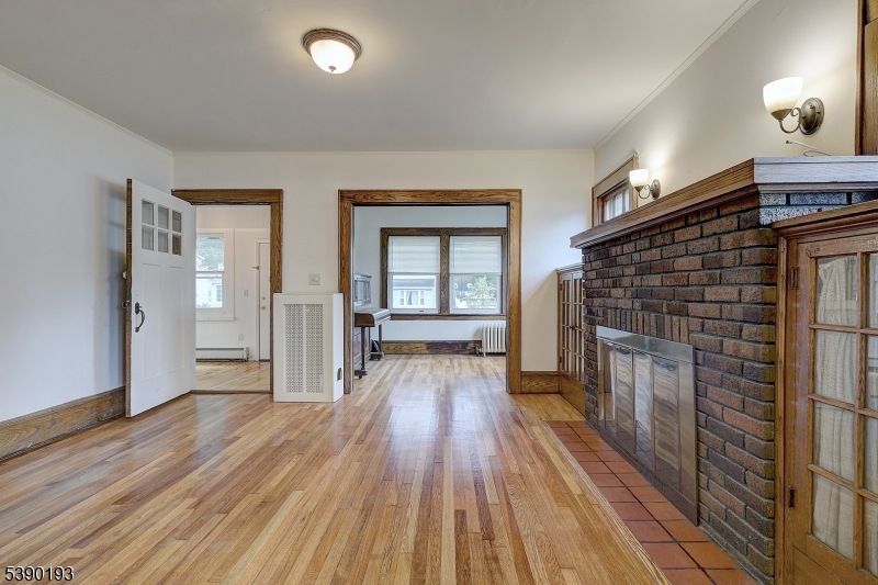24 Brook Street Springfield, NJ 07081 - Photo 6 of 28 an empty room with wooden floor and fireplace