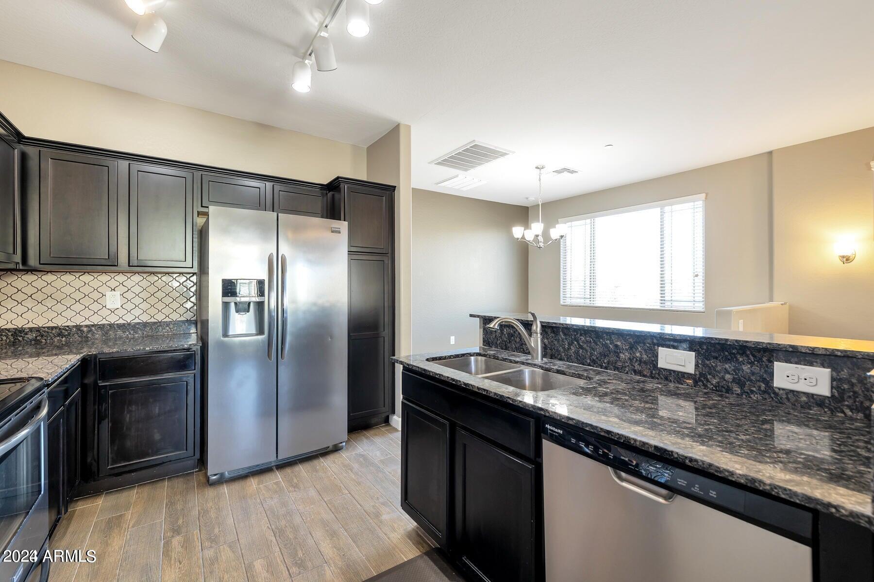 2150 West Alameda Road, Unit 1169 Phoenix, AZ 85085 - Photo 24 of 26 a kitchen with granite countertop kitchen island stainless steel appliances a sink stove and refrigerator