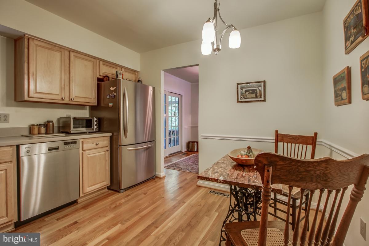 1814 Cranberry Lane Reston, VA 20191 - Photo 11 of 30 a kitchen with stainless steel appliances granite countertop a stove a refrigerator a sink dishwasher a dining table and chairs with wooden floor