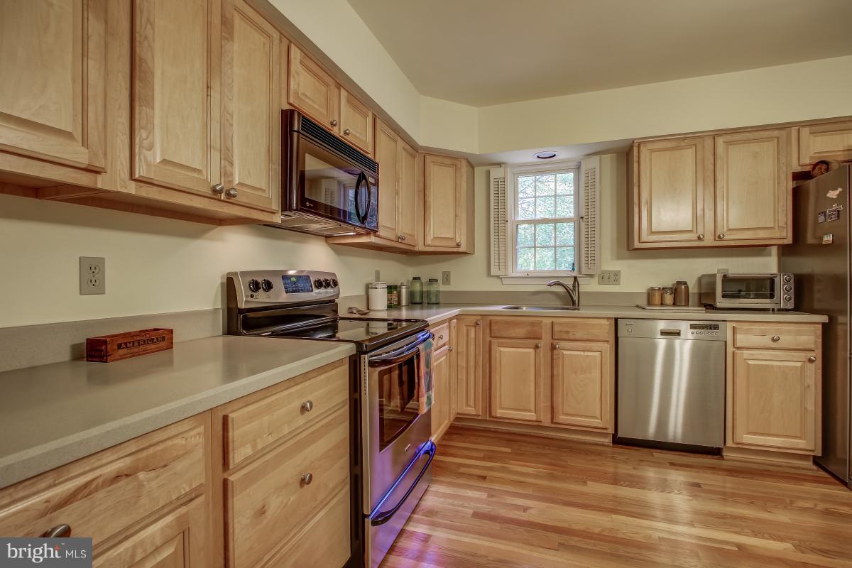 1814 Cranberry Lane Reston, VA 20191 - Photo 12 of 30 a kitchen with stainless steel appliances granite countertop a stove a sink dishwasher and a microwave oven with wooden cabinets