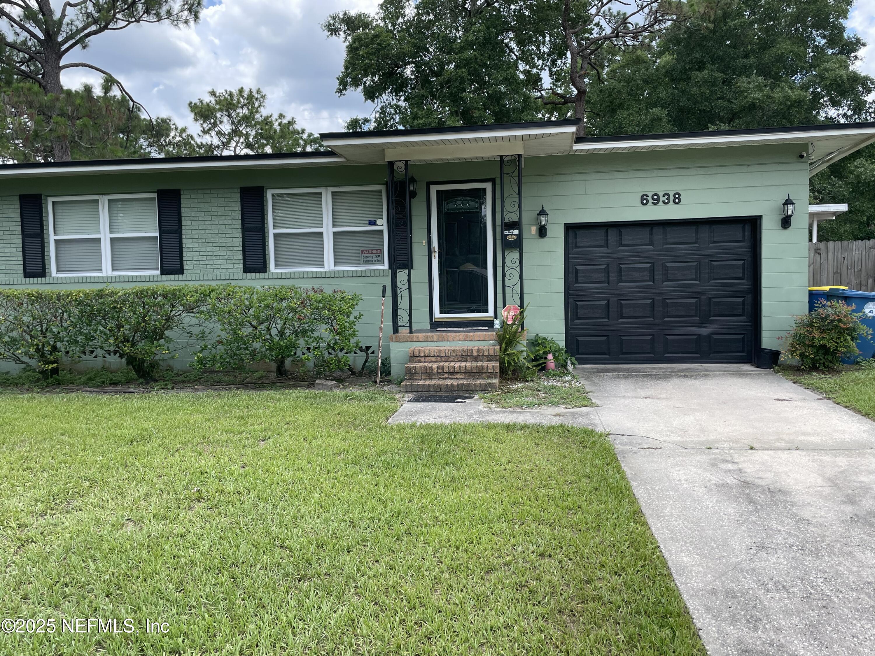 6938 Corkwood Road Jacksonville, FL 32277 - Photo 2 of 25 a front view of a house with garden