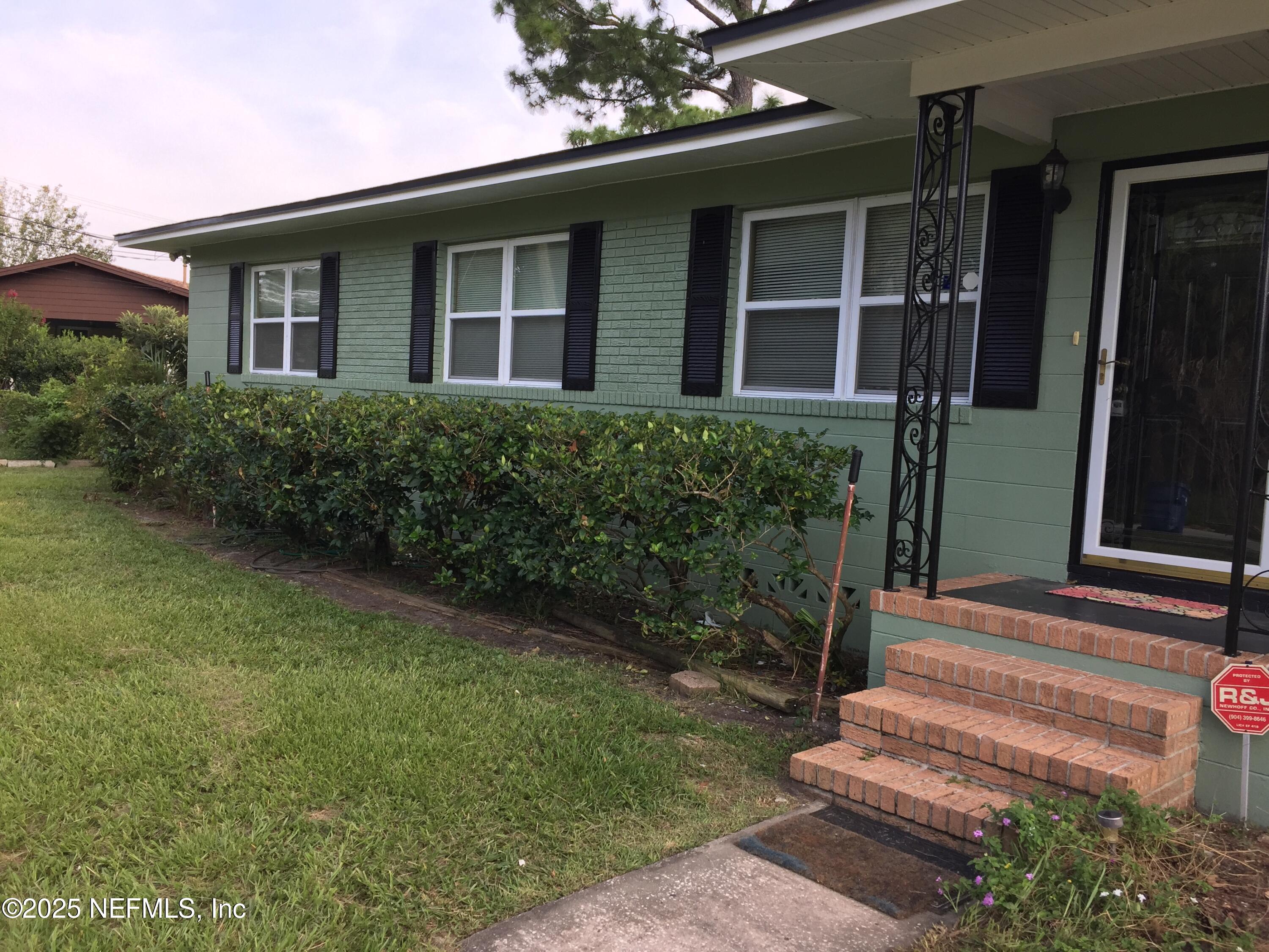 6938 Corkwood Road Jacksonville, FL 32277 - Photo 3 of 25 a front view of a house with a yard