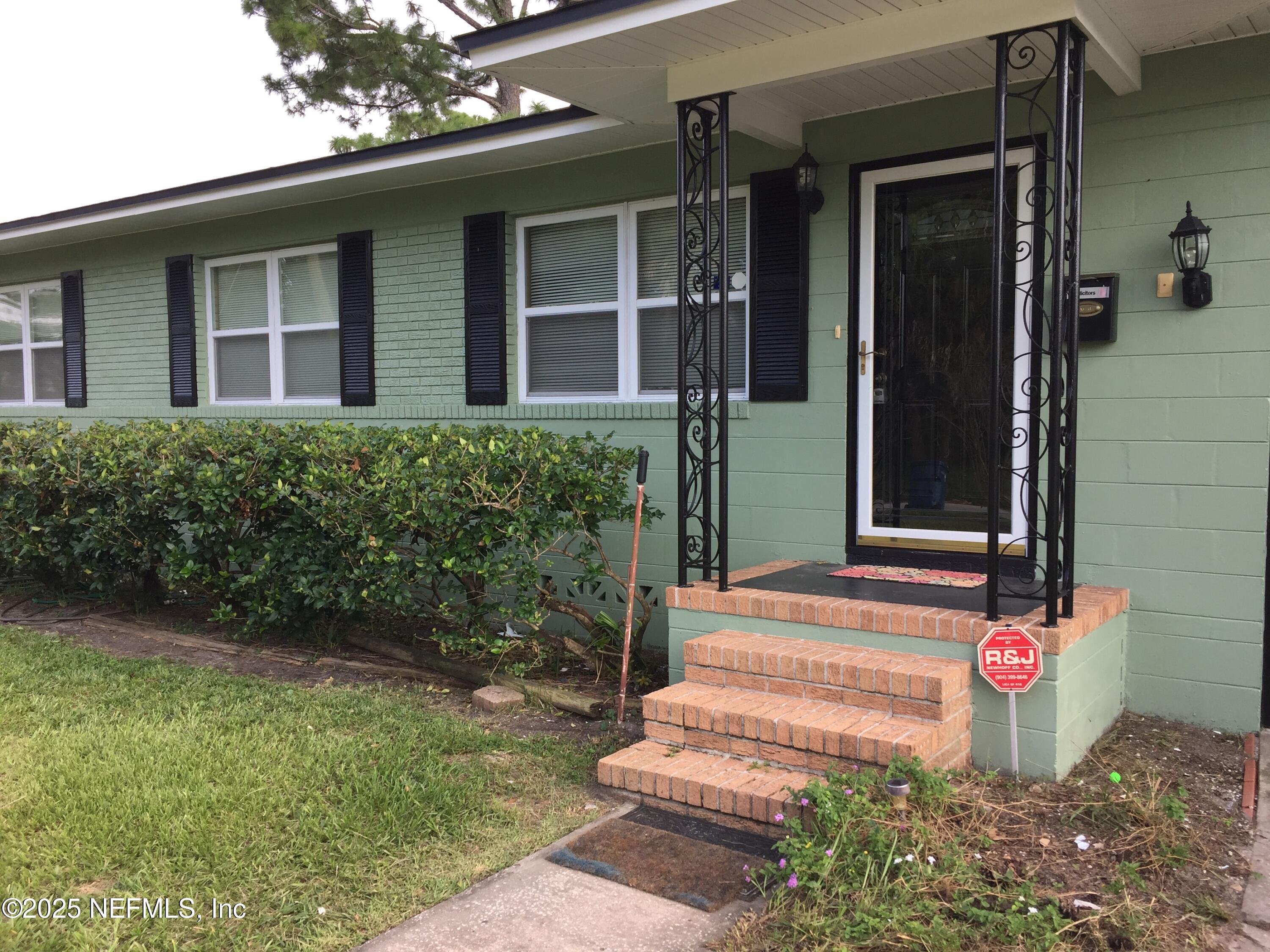 6938 Corkwood Road Jacksonville, FL 32277 - Photo 4 of 25 a front view of a house with a yard and fountain