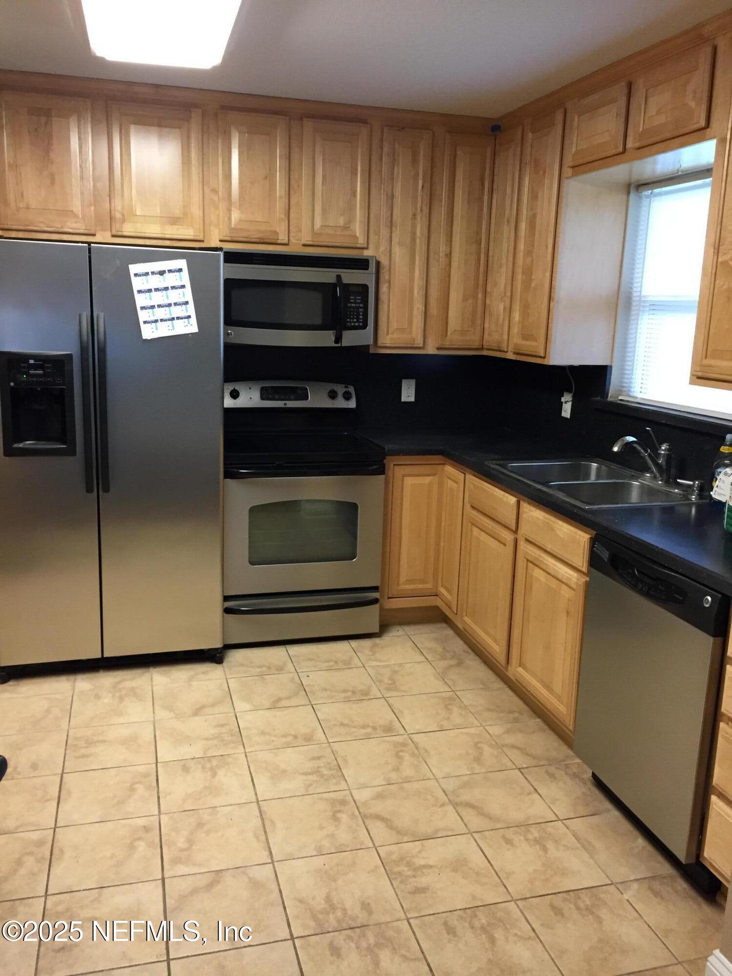6938 Corkwood Road Jacksonville, FL 32277 - Photo 7 of 25 a kitchen with a sink and cabinets