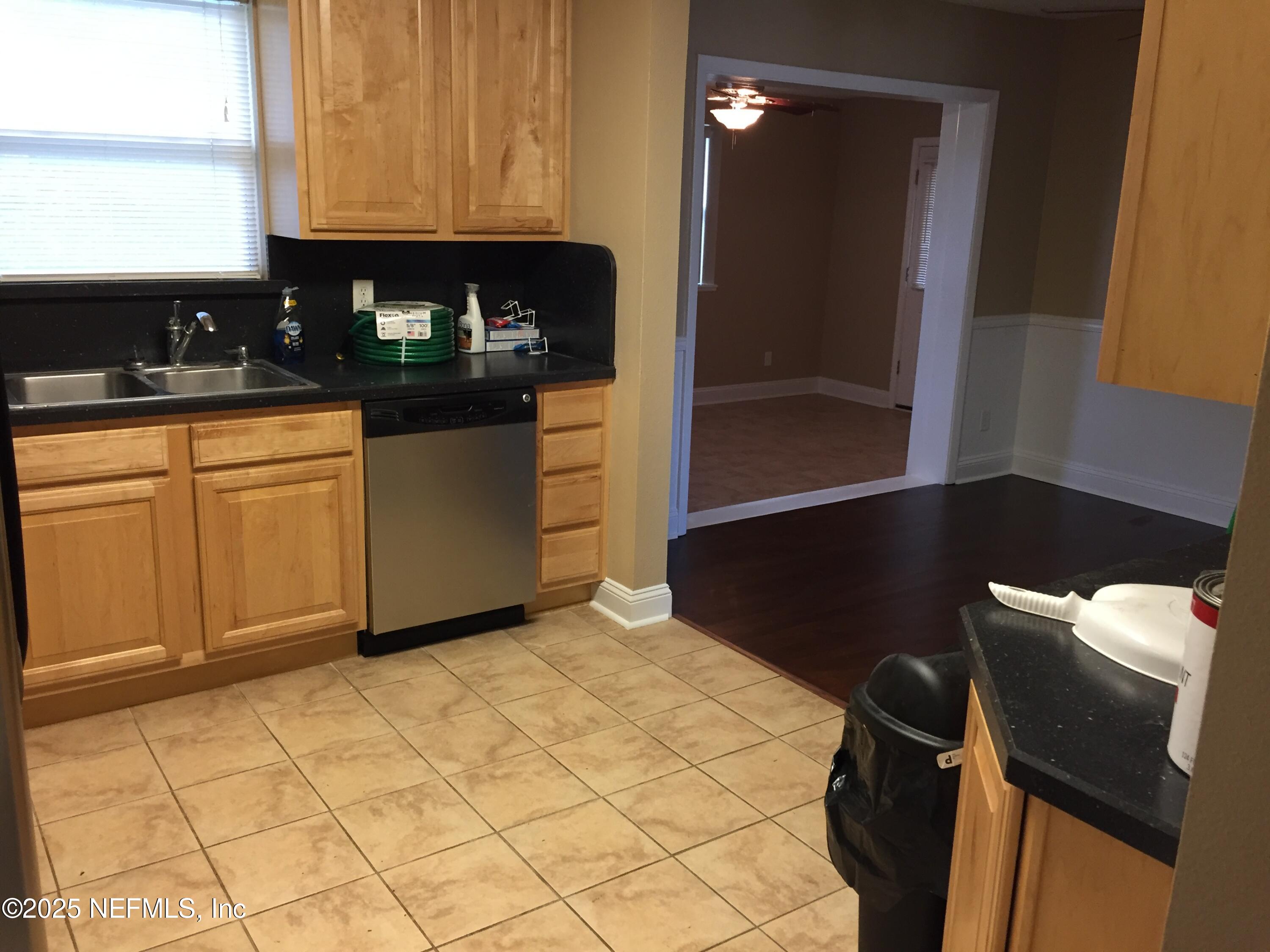 6938 Corkwood Road Jacksonville, FL 32277 - Photo 8 of 25 a kitchen with a sink a refrigerator and cabinets