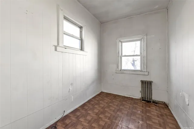 a view of empty room with window and hardwood