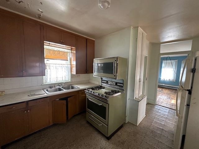 412 Monroe Street Eveleth, MN 55734 - Photo 4 of 22 Kitchen with dark tile flooring, stainless steel appliances, backsplash, and sink