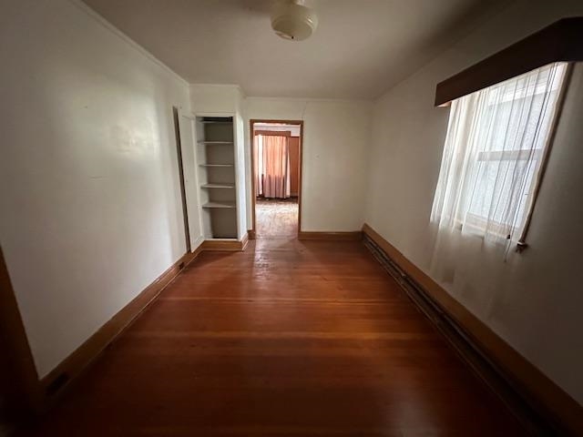 412 Monroe Street Eveleth, MN 55734 - Photo 6 of 22 Hallway featuring dark hardwood / wood-style flooring, built in shelves, and baseboard heating