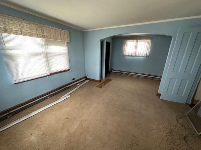 412 Monroe Street Eveleth, MN 55734 - Photo 10 of 22 Empty room featuring a baseboard heating unit, ornamental molding, and carpet flooring