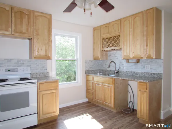 a kitchen with stainless steel appliances granite countertop a sink stove and cabinets