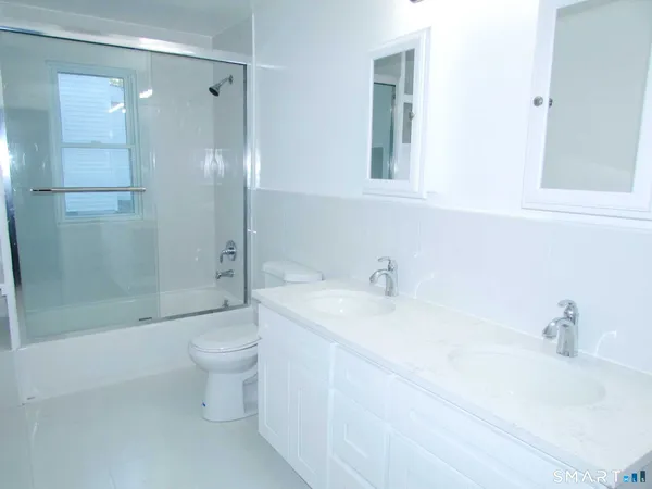 a bathroom with a sink a toilet and shower