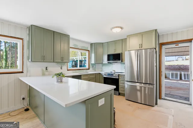 a kitchen with a refrigerator a sink and cabinets