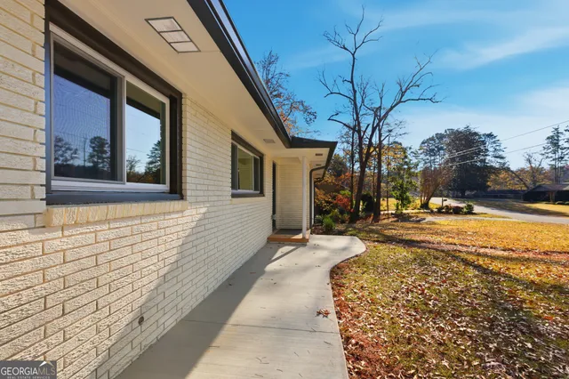 a view of a brick house with a large tree