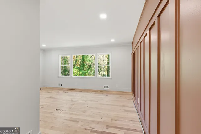 an empty room with wooden floor and a window